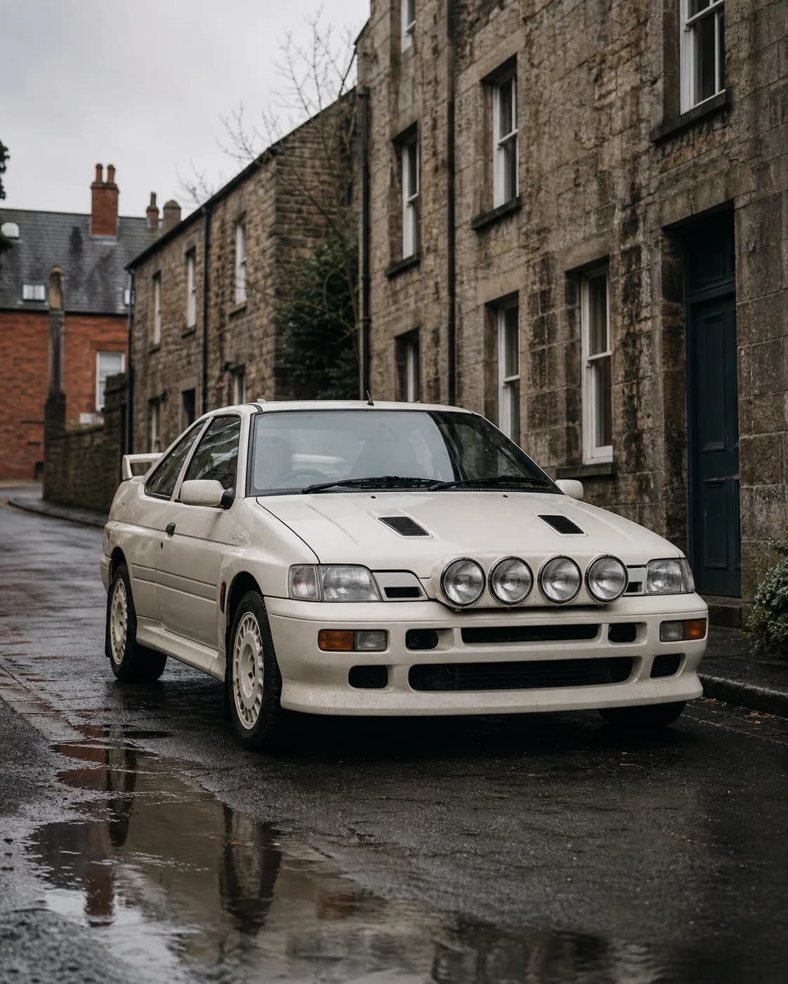 White rally-inspired compact coupe parked on a wet stone street